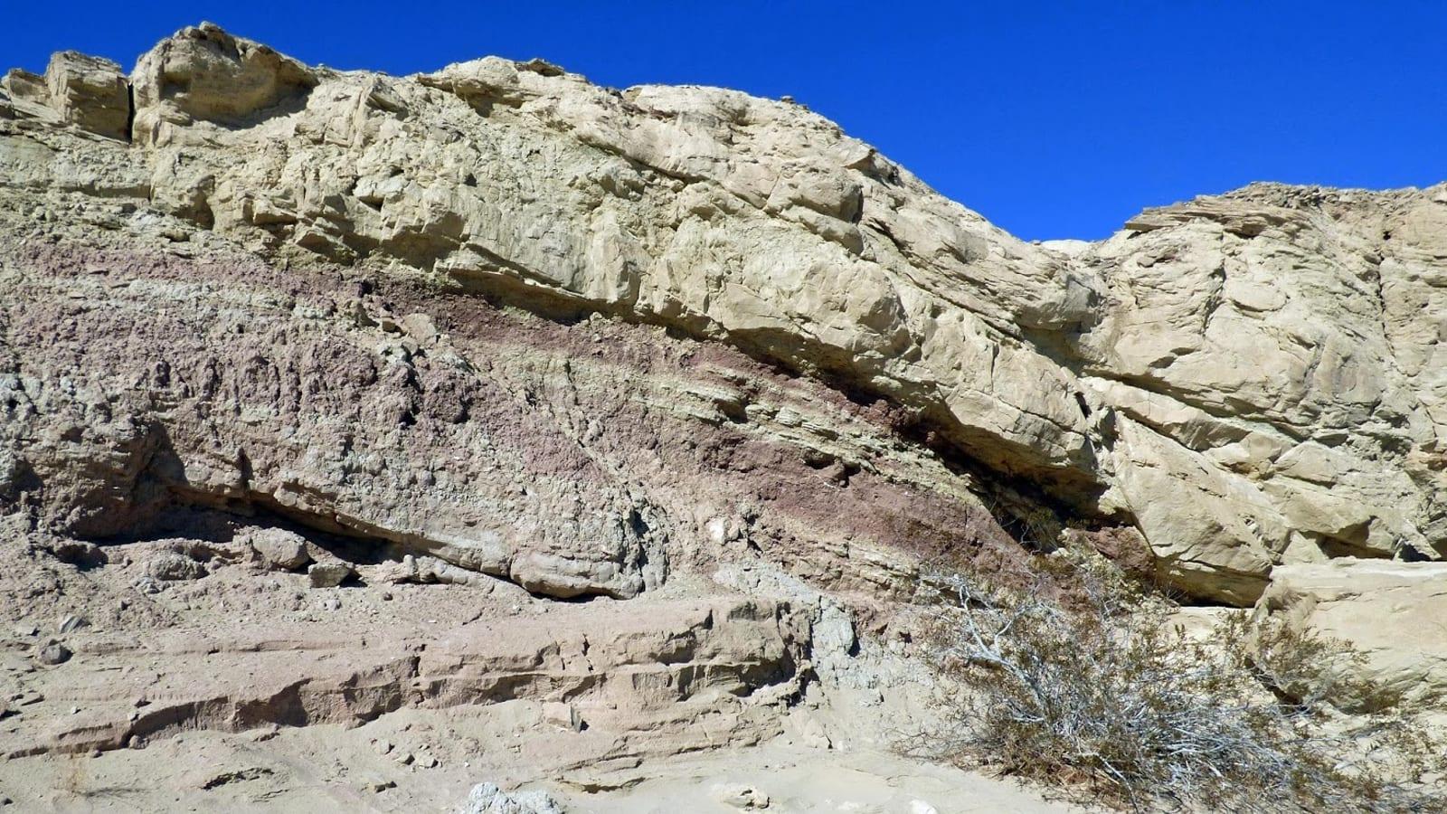 Multicoloured layered sedimentary cliff and dry desert wash exposed at the Yuha Basin fossil locality, California.