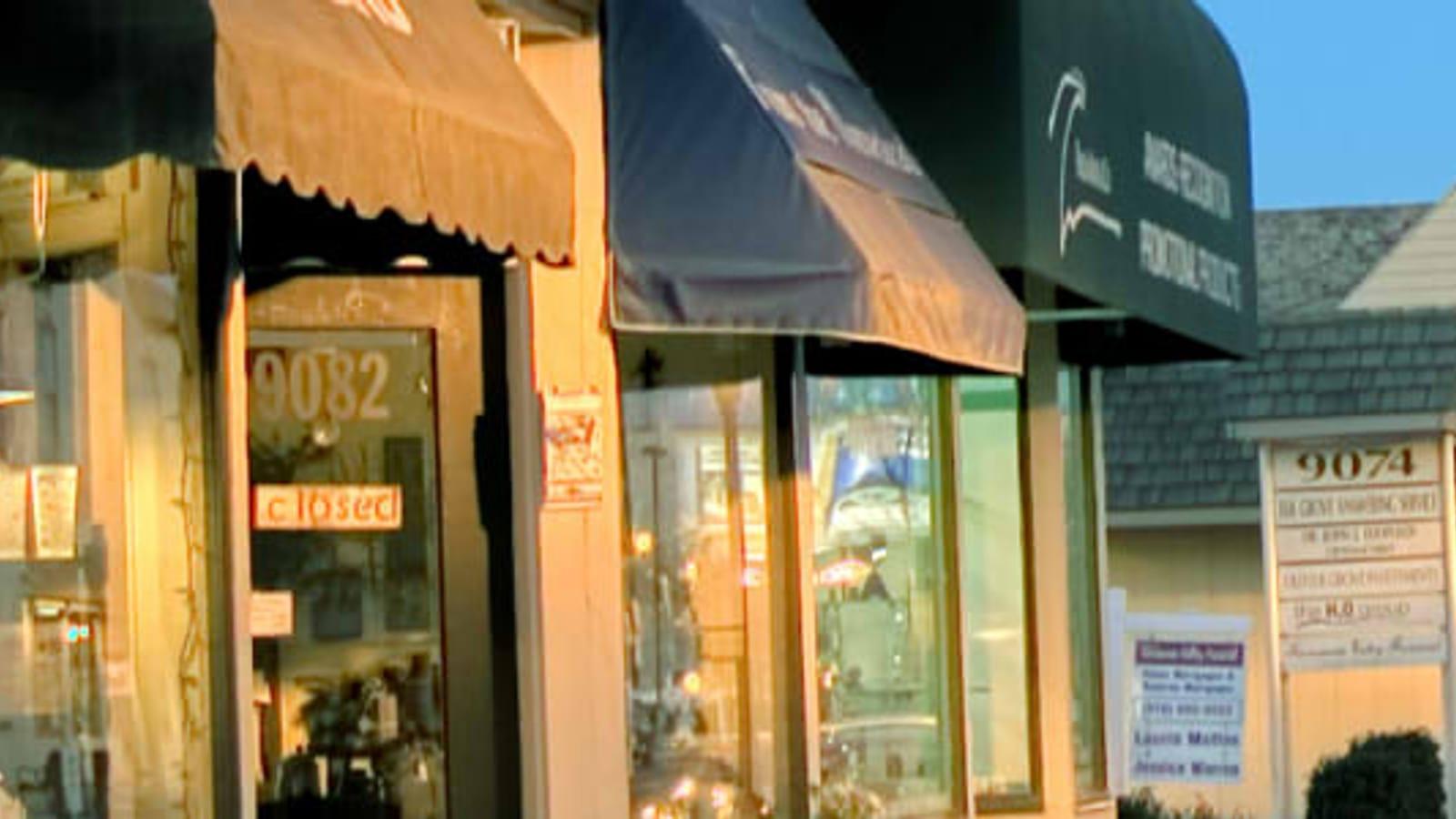 Small commercial street with closed storefronts and awnings photographed at dusk in the Elk Grove area, California.