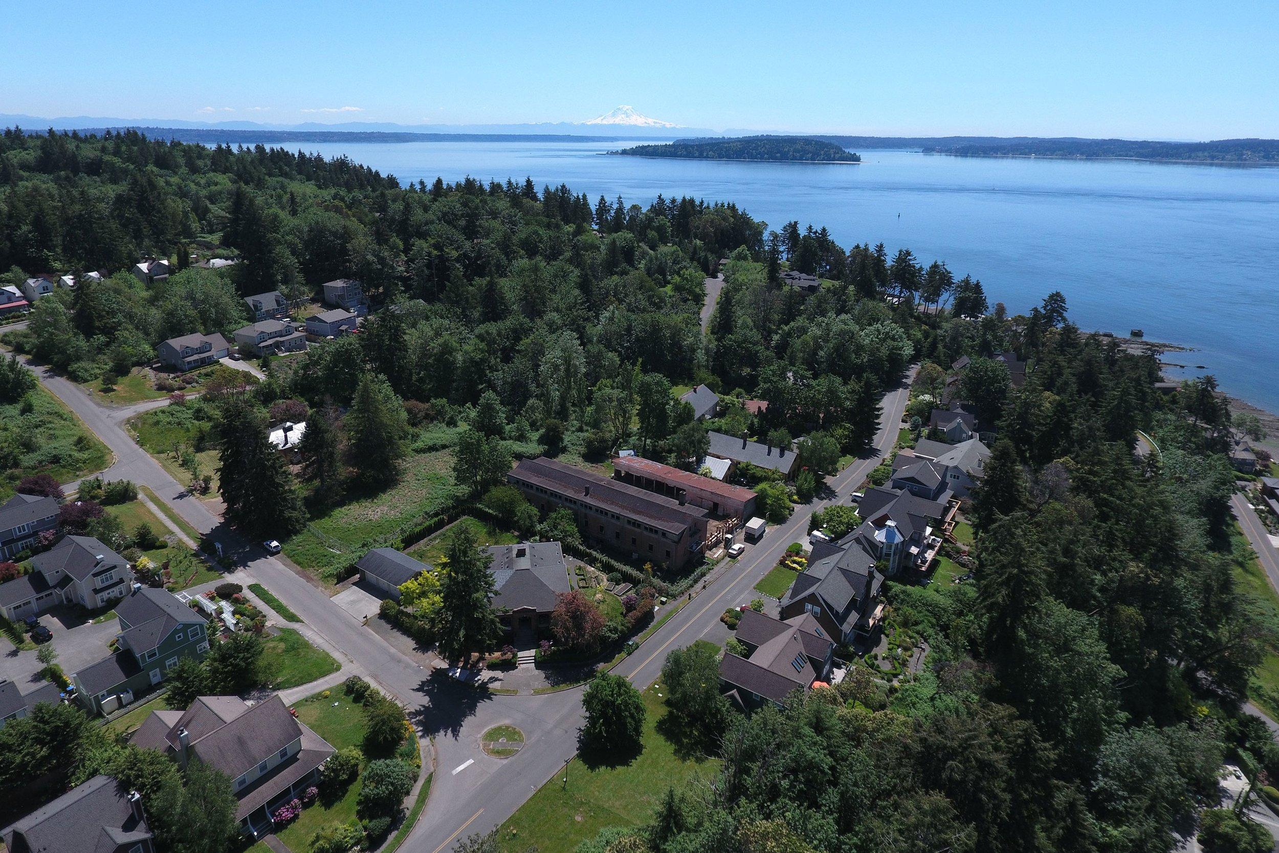Tilted Blakeley Formation sandstone exposed on the shoreline at Fort Ward Park, Bainbridge Island, Washington, with Rich Passage and the Kitsap Peninsula in the background.