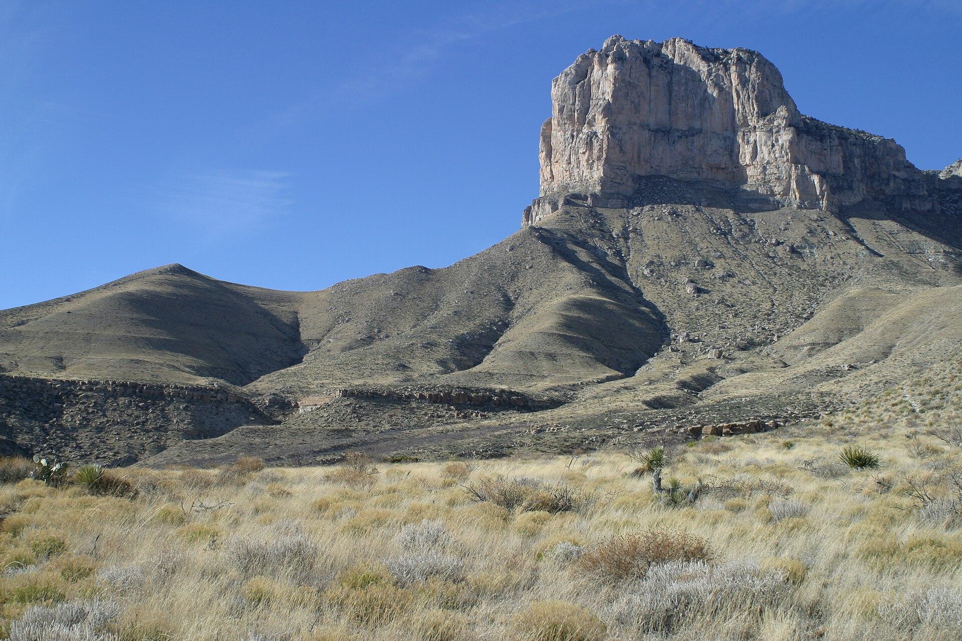 Buff cliff face of El Capitan rising above grassy desert flats at Guadalupe Mountains National Park, west Texas.