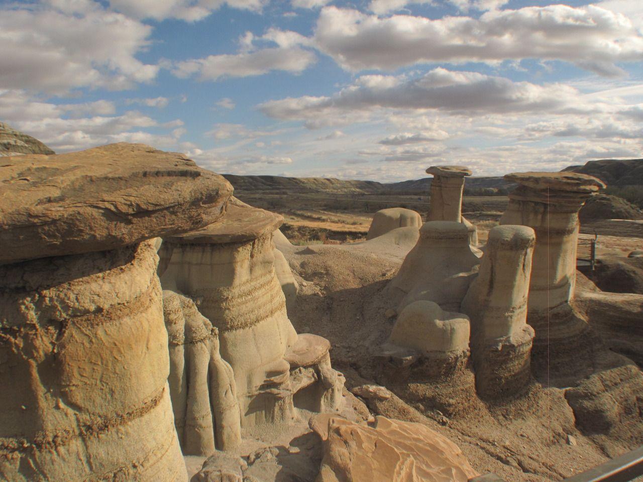 View into the U-shaped Horseshoe Canyon near Drumheller, Alberta, with layered Cretaceous sediments and dry creek bed below.
